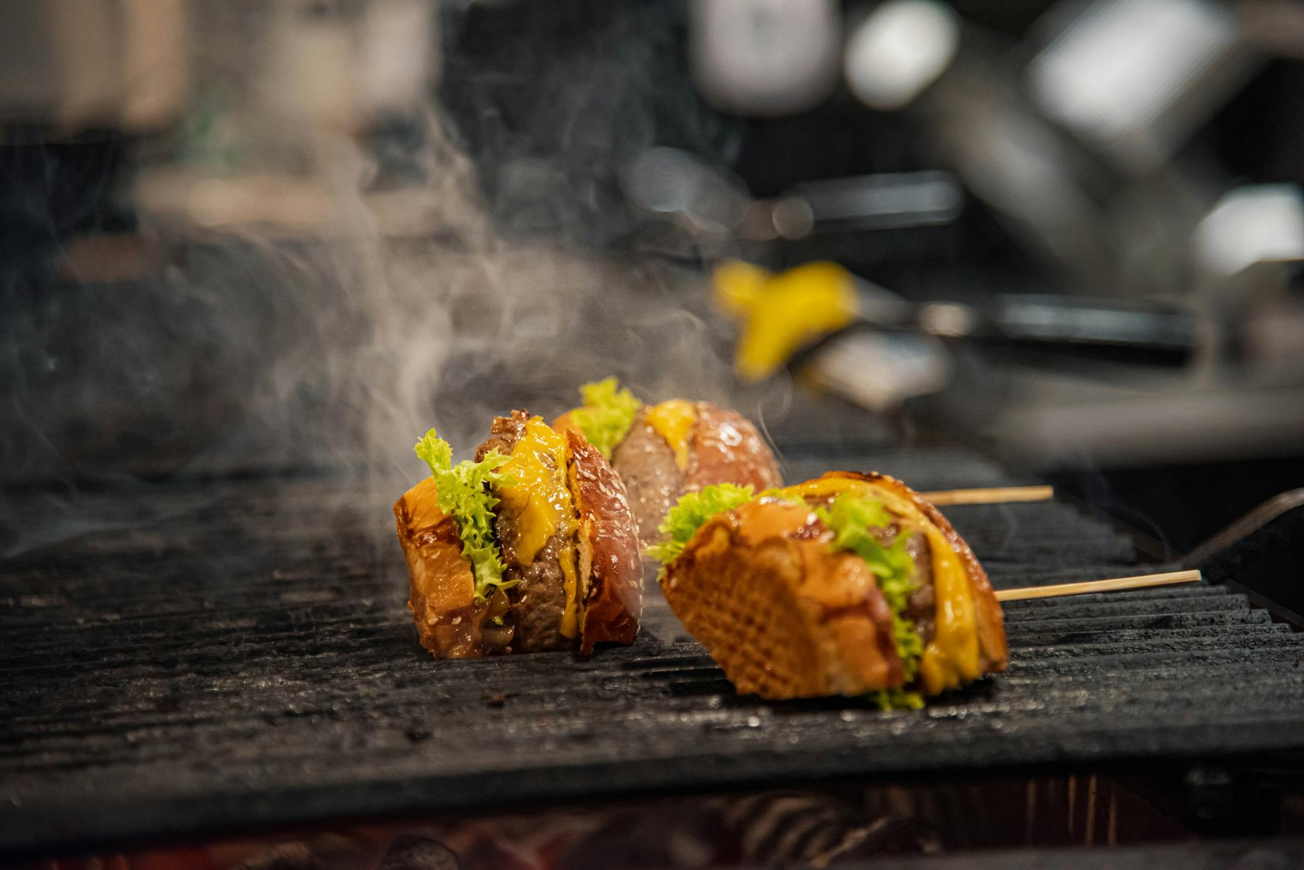 Burgery z serem i sałatą skwierczące na grillu w aromatycznej marynacie