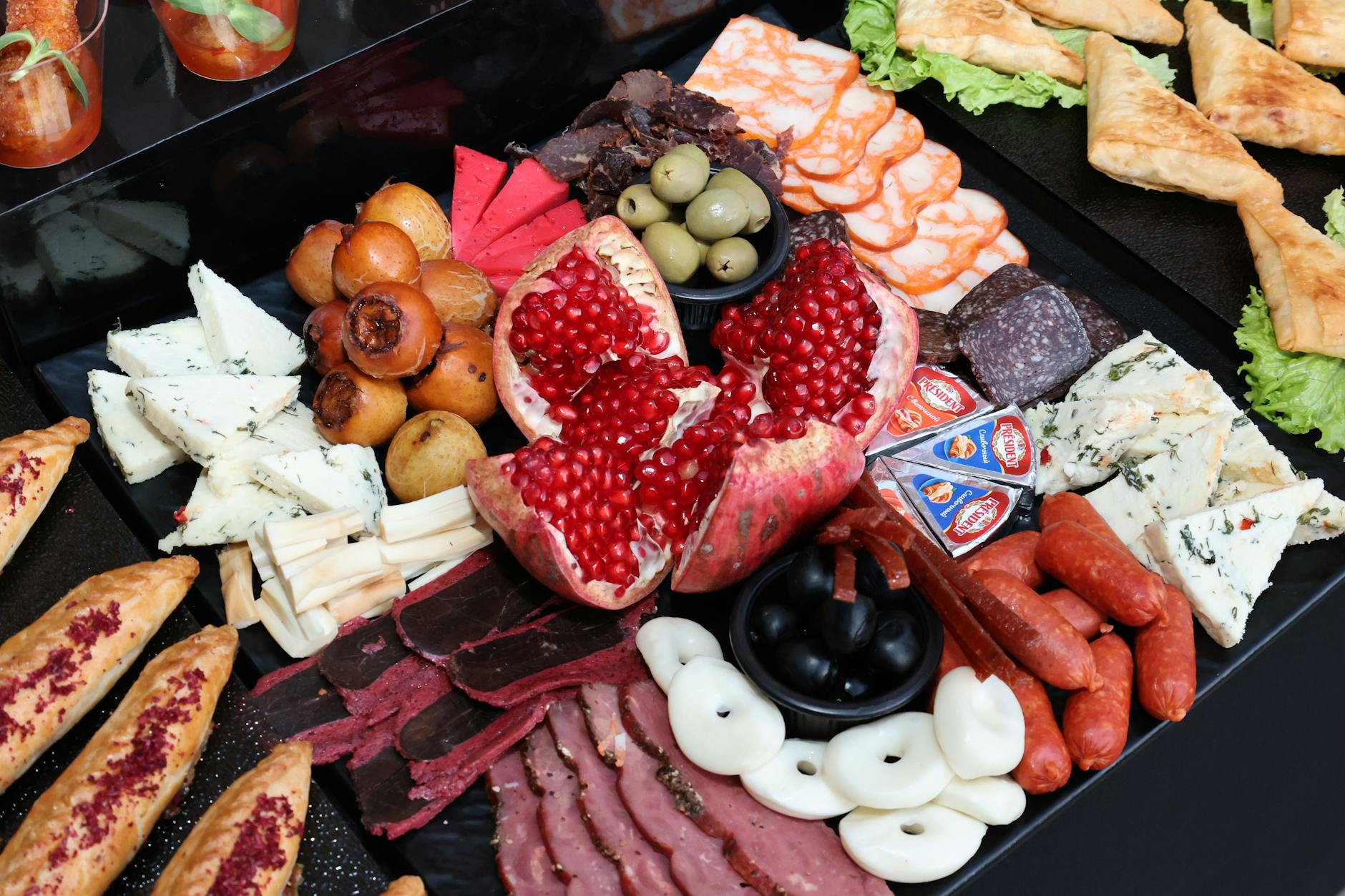 Kolorowa deska z serami, wędlinami, owocami i warzywami na przyjęcie