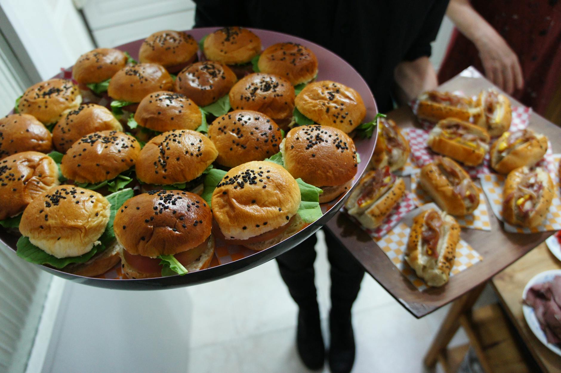 Jak przygotować deskę street food: mini burgery, rollsy kebabowe i dodatki na wspólny wieczór Tace z mini burgerami i hot dogami przygotowane na imprezowy wieczór